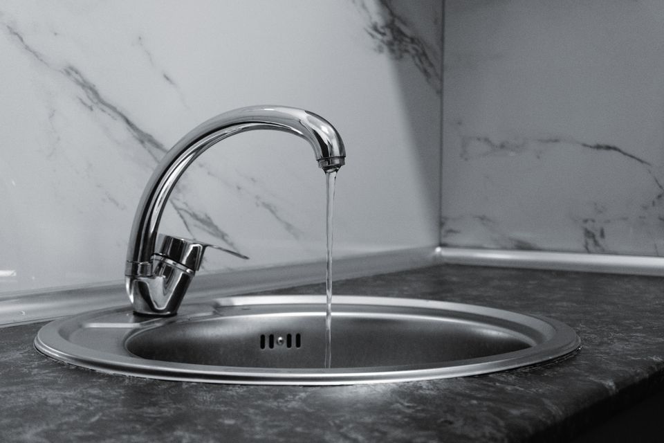 Kitchen faucet running into a stainless sink